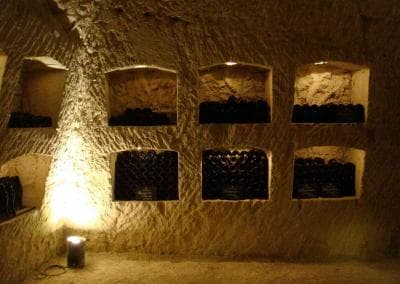 Ein mit Weinflaschen gefüllter Raum in einer Höhle.