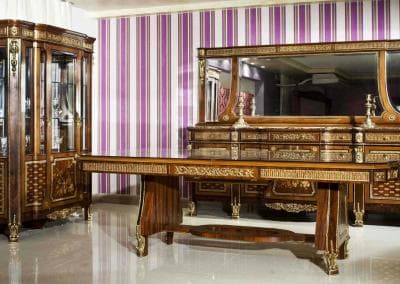 Ein kunstvoll geschnitztes Möbelset in einem Raum mit violetten Wänden.