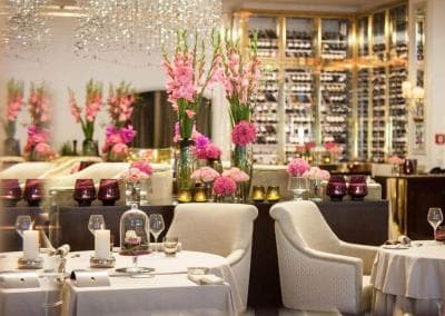 Ein Restaurant ist mit rosa Blumen und einem Kronleuchter dekoriert.