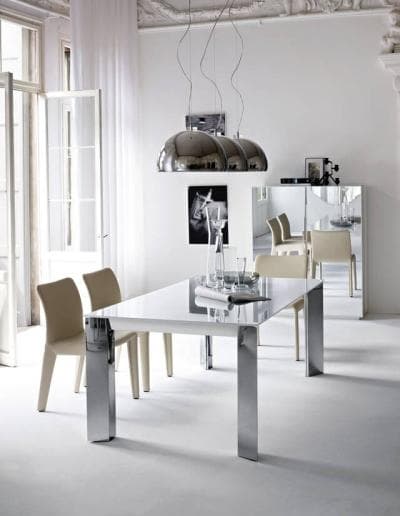 Ein modernes Esszimmer mit einem weißen Tisch und Stühlen.